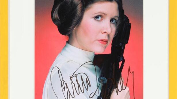 Signeret farvepromoveringsfotografi af den amerikanske skuespillerinde Carrie Fisher. Vurdering- 4.000 kr.