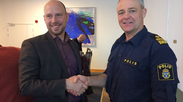 Hans Lindberg, kommunstyrelsens ordförande, skakar hand med Ronny Adolfsson, chef för lokalpolisområde Umeå.