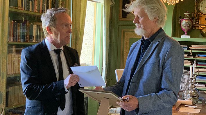 Författaren Lars Andersson tar emot Kulturpriset till Göran Tunströms minne av kultur- och näringslivschefen i Sunne, Per Branzén. Platsen är biblioteket på Mårbacka.