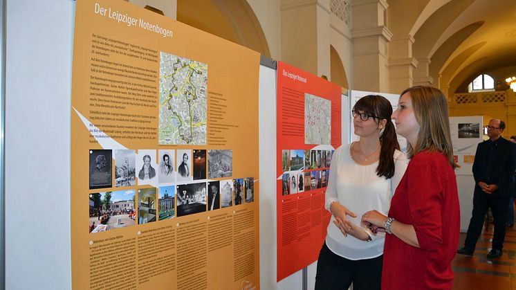 Besucherinnen vor den Informationstafeln zum Leipziger Notenbogen und zum Leipziger Notenrad