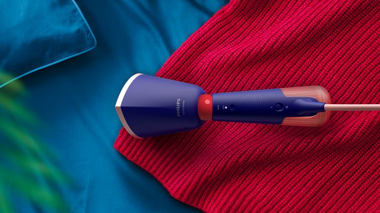 Philips håndholdt steamer på en rød strikkegenser