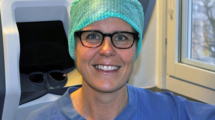 Malin Brunes, läkare på Kvinnokliniken Södersjukhuset, stående framför en av sjukhusets operationsrobotar. Foto: Privat