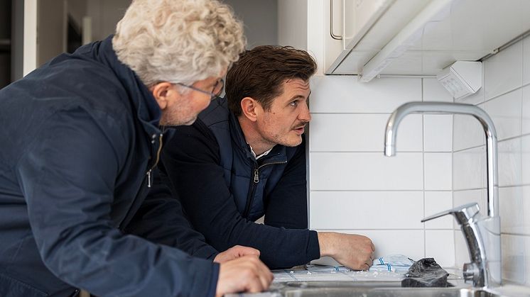 Joakim Becker, Elektroskandia och Chris Strandell, ELKO på besök i en av lägenheterna där de inspekterar hörnboxen i köket.