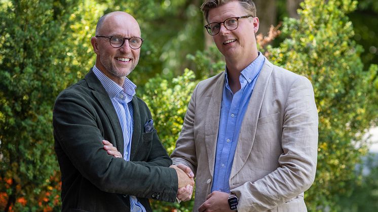 Mikael Sjölund, vd Coreco och Peter Björk, affärsområdesansvarig för Byggfakta Tender, tar i hand för ett nytt samarbete mellan bolagen.