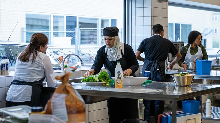 Kursister på flygtningeforløbet er i gang med at forberede mad til deres afslutningsmiddag.