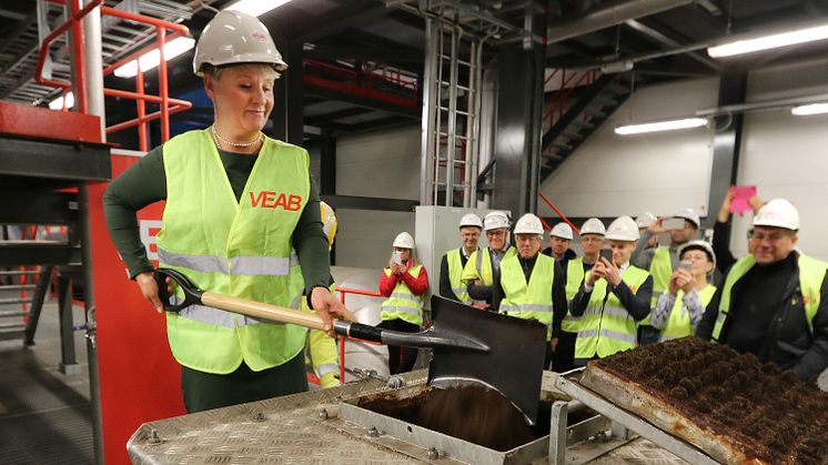 Anna Tenje, kommunstyrelsens ordförande i Växjö, skyfflar i det sista lasset torv i Sandviksverket. 