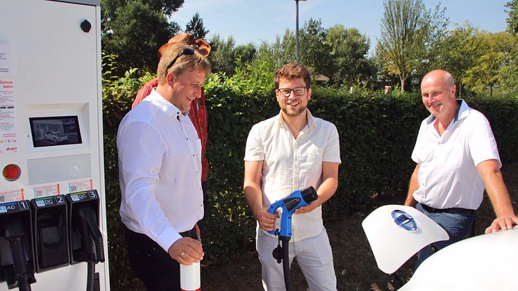 Bürgermeister Gerald Brehm (r.) und Thomas Oppelt (M.) vom Stadtmarketing nehmen gemeinsam mit Bayernwerk-Kommunalbetreuer Ralf Schwarz (l.) die neue Schnelladesäule am Parkplatz „Engelgarten“ in Höchstadt an der Aisch in Betrieb.