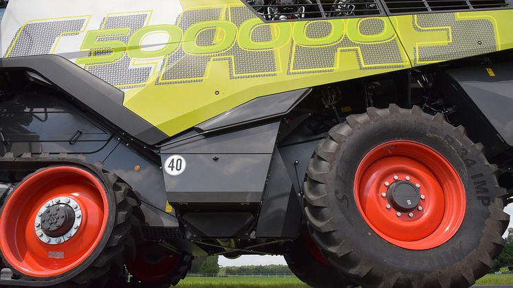 The CLAAS lettering is partially transparent thanks to the punched-out knotter hook pattern, the seed green “500000” stands out from the metallic paintwork of the machine.
