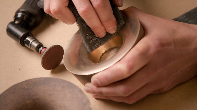 A tea light candle holder is carefully polished