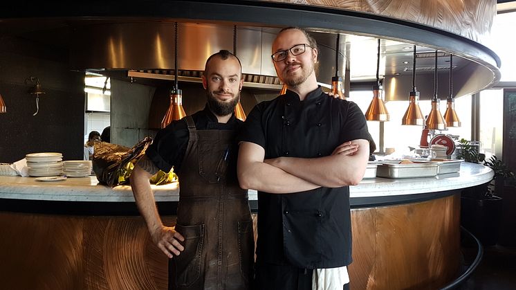 Bild: Från vänster Viktor Garrido Luis, chef deputie och vars schema vår studerande Christofer Hammar till höger följer.  I bakgrunden jättekolgrillen.