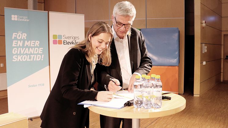 Ebba Kock, ordförande Sveriges Elevkårer skriver under Deklaration för en stark demokrati tillsammans med Peter Örn, ordförande för regeringens kommitté Demokratin 100 år.