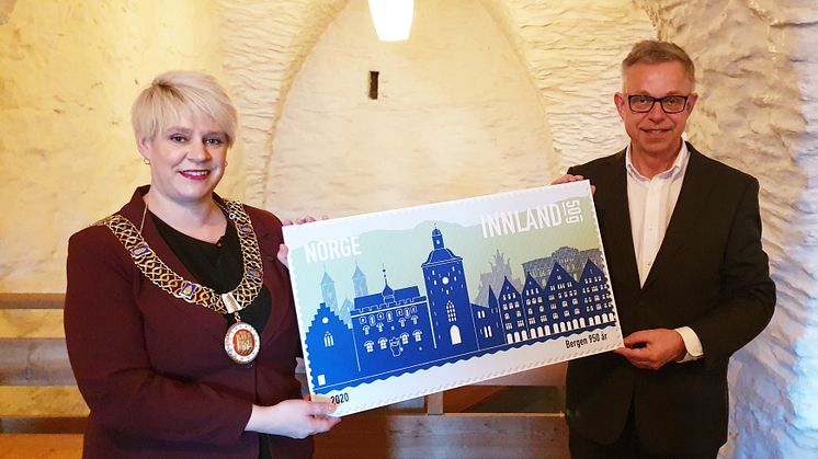 Ordfører Marte Mjøs Persen og frimerkedirektør Halvor Fasting viser fram jubileumsfrimerket for Bergen 950 år. Lanseringen skjedde i historiske Håkonshallen.