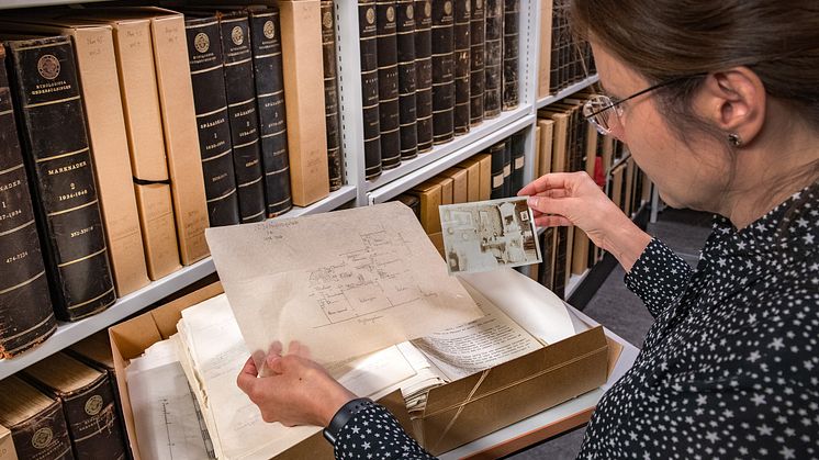 Forskningsarkivarie Marie Steinrud tittar i Birgit Gejvalls bostadsundersökning. Foto: Peter Segemark, Nordiska museet.