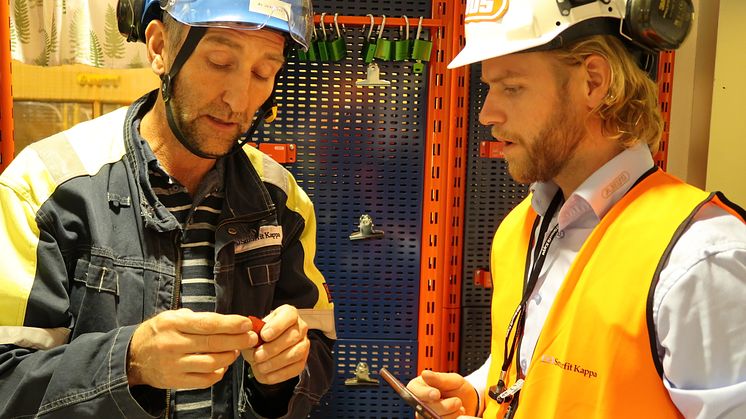 Bo Johansson från Smurfit Kappa och Erik Wikström från Abus tittar på hänglåsen i ett av kontrollrummen inne i fabriken.