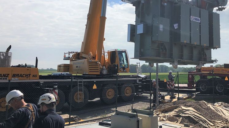 Der 32-Tonnen-Trafo wird vom Schwertransporter per Lastkran auf das neue Fundament gesetzt.