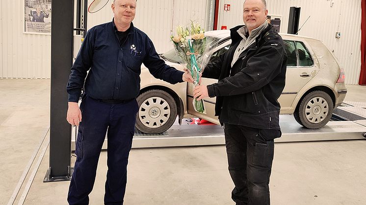Bilprovningen firar sin nyöppnade station på Ekerö med att ge blommor till den första kunden. Foto: Bilprovningen