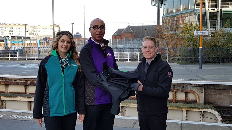  A London Northwestern Railway revenue protection officer and West Midlands Railway driver handing over old uniforms to Justin Frost from The Salvation Army Trading Company at Birmingham Snow Hill station