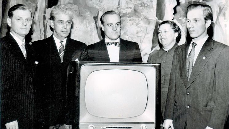 Det är den 11 mars 1957 och Högsjöpremiär för TV som aftonunderhållning. Styrelsen i Högsjö Arbetarekommun är samlad  kring TV–apparaten. Från vänster kassören Martin Olsson, .Erik Andersson, Lennart Wallin, Mery Axelsson och Göte Östlund.