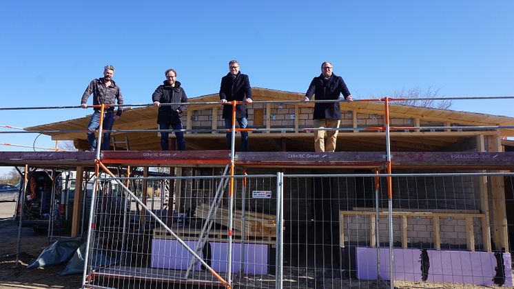 Pächter Benny Biehl, Architekt Dipl.-Ing. Volker Binding, Tourismusdirektor Oliver Behncke und Klaus-Heinrich Witt, Inhaber der Dachdeckerei Witt.Fehmarn GmbH & Co. KG, sind zum kleinen Richtfest vor Ort auf der Baustelle in Lemkenhafen.©TSF_LR