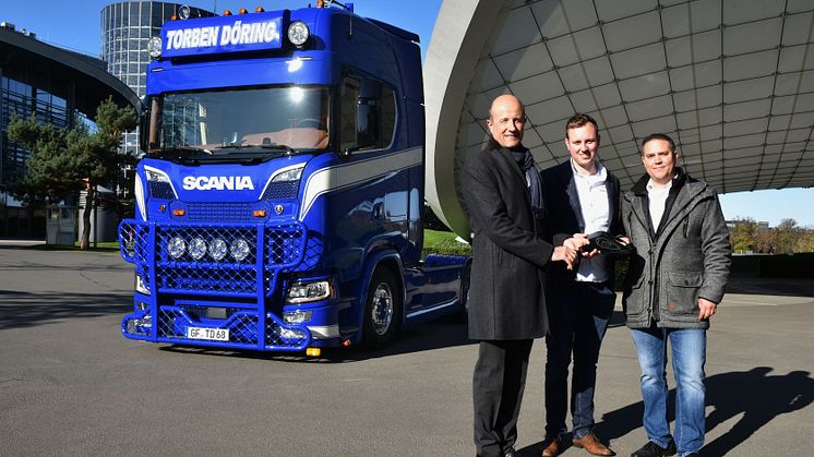 Stephan de Haar (li.), Leiter Erlebniswelten der Autostadt in Wolfsburg und Lars Rehberg (re.), Verkauf Neufahrzeuge Scania, gemeinsam mit Torben Döring, Geschäftsführer der Spedition Torben Döring, bei der ersten Lkw-Übergabe in der Autostadt.