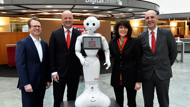 (v.li.) Dr. Bernd Hochberger, Ralf Fleischer, Marlies Mirbeth und Stefan Hattenkofer mit Roboter "Monaco Pepper" im neu eröffneten Digital-Center der Stadtsparkasse München.
