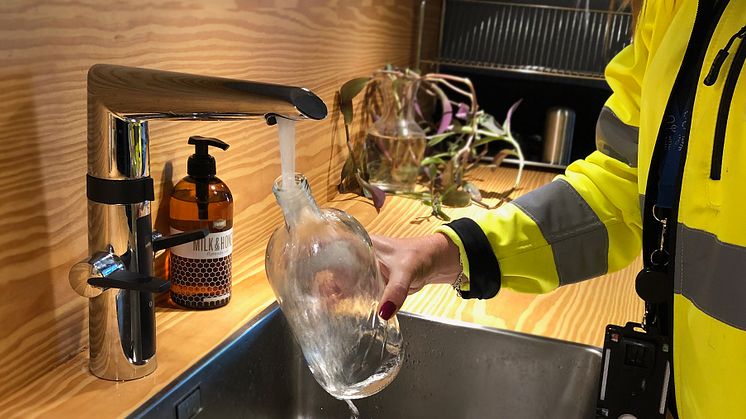 Nacka vatten och avfall tappar upp kranvatten på kontoret