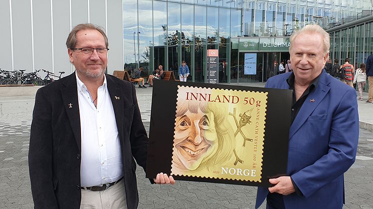 Jo (til høyre) og Håkon Vestly hadde et nært forhold til Knerten i oppveksten. Her viser de fram frimerket med moren. Det er tatt på Anne Cath Vestlys plass i Oslo, foran det nye Deichmanske bibliotek.
