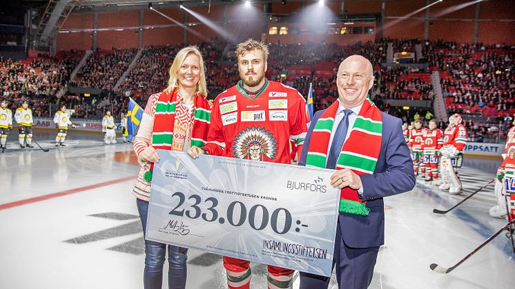 Sven-Erik Kristensen från Bjurfors räcker över checken på 233.000 kronor till Madeleine Wahlberg, insamlingsstiftelsen för Drottning Silvias Barn & ungdomssjukhus.  Assisterar gör Sebastian Stålberg,  Frölunda Indians. Foto: SE360.