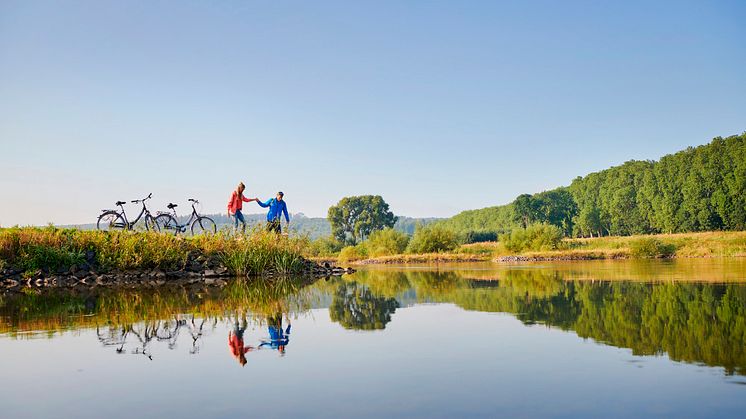Weser-Radweg_Paar mit Fahrrädern macht Pause an der Weser (c) DZT, Jens Wegener.jpg
