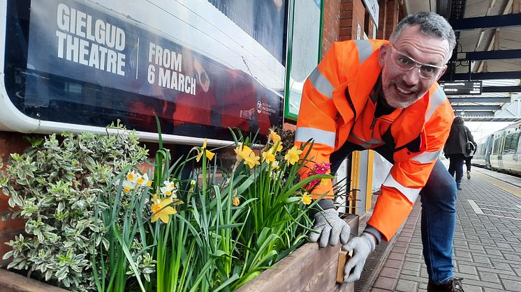A volunteer tidies up one of the station's flower beds