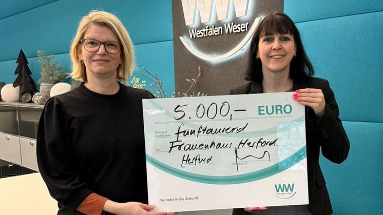 Nadine Heinen (links), Traumapädagogin beim Frauenhaus Herford, nimmt die Spende von Christiane Rüsel (rechts), Kommunalreferentin bei Westfalen Weser, entgegen.