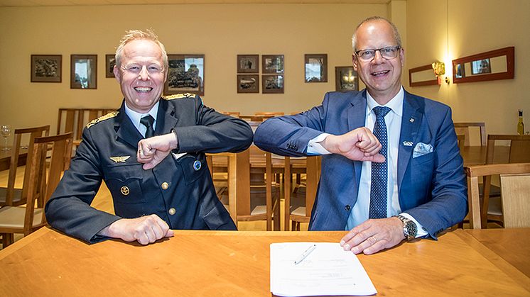 Flygvapenchefen Generalmajor Carl-Johan Edström och Stefan Oscarsson, Customer Director Government & Space GKN Aerospace, gör ett coronasäkert "handslag" vid signeringen av PBL-kontraktet.