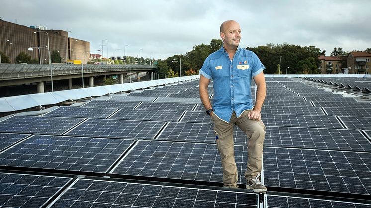 Säljchef Martin Garmstedt på OKQ8 Västberga står på stationens tak där solcellsanläggningen är installerad 