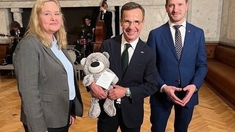 Vänsterpartiets vice partiledare Ida Gabrielsson lämnade över Mr. Mandel till Ulf Kristersson vid hans 60-årsmottagning. För nallen väntar nu nya äventyr med Sveriges Statsminister. 