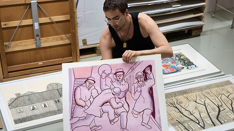 Konstnären Afrang Nordlöf Malekian i arbete med Statens konstråds grafiska samling. Info om konstverket i bilden: Birgit Ståhl-Nyberg, ”Happy boys”, 1976, litografi. Foto: Paul Kokamägi / Statens konstråd.  