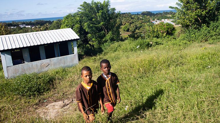 Jeudi och Juliano, 9 år, går uppför slänten från en av toalettanläggningarna på deras skola i Madagaskar. På skolan går 840 barn och det finns fem toaletter. Dock är flera ofta avstängda på grund av vattenbrist. Foto: Ernest Randriarimalala/WaterAid