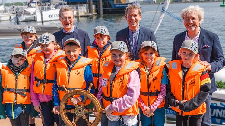 Frank Meier, Dr. Ulf Kämpfer und Uwe Wanger überreichen den Segelkindern das Steuerrad, um in eine erfolgreiche 22. Segelcamp-Saison zu starten.