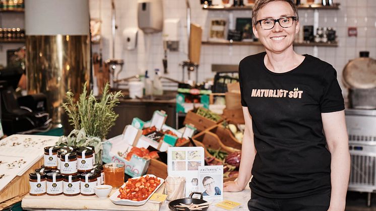 Biodlaren Therese Hammargren laddar upp svenska jordgubbar  på Stockholms Matmarknad med primörhonungen. Foto: Anders Thessing