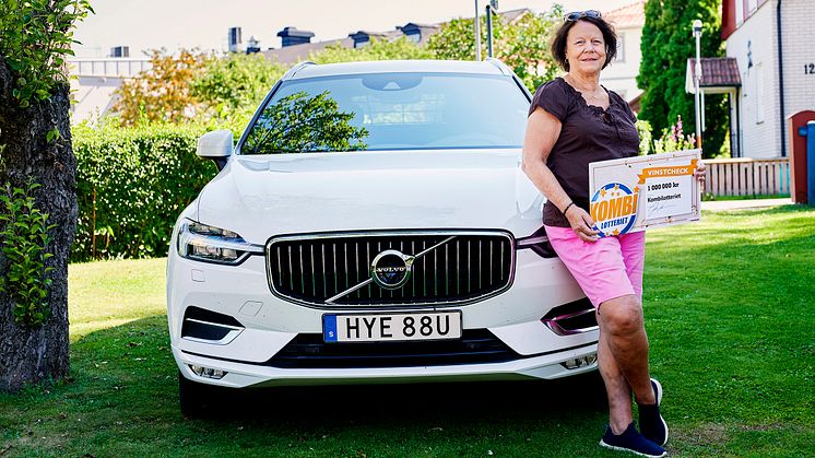 En stolt Eva poserar framför sin Volvo XC60.