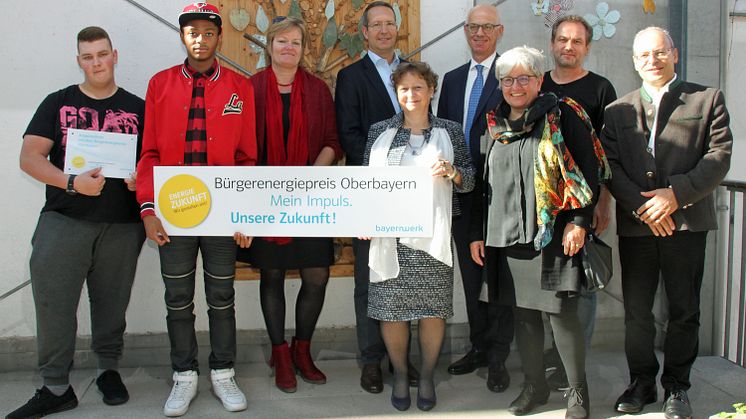 Zum Auftakt in der Mathilde-Eller-Schule stellten Regierungsvizepräsident Walter Jonas (3.v.r.) und Ingo Schroers, Leiter Kommunalmanagement (4.v.r.), den Bürgerenergiepreis Oberbayern beim Vorjahressieger in München vor.