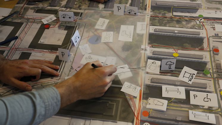 Workshop participant sketching on a design proposal for a shared space in a residential area. Photo: Bo Westerlund