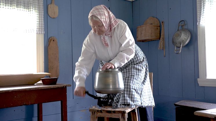 Anno Odalstunet formidler bruk av gjenstandene i museets samling. Birgitta Andreassen demonstrerer kjerning (kjinning) av smør. Foto: Anna Løvlund