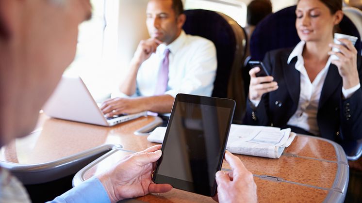 Businesspeople On Train Using Digital Devices