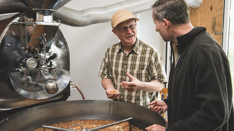 Ilario Garbani (li) und Besucher beim Mais-Mahlen, Tessin