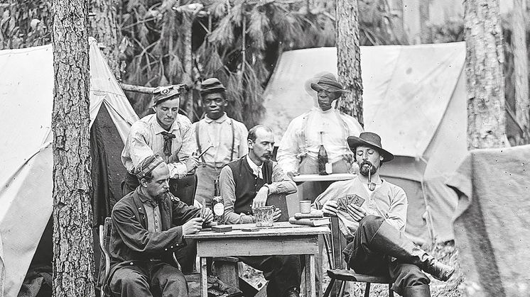 Officerare ur 114. Pennsylvania infantry spelar kort i ett fältläger. Förbandet är från unionssidan och de färgade är anställda tjänare ... (ur Amerikanska inbördeskriget, s. 10)