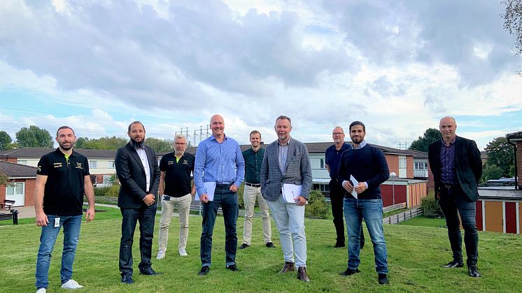 De närvarande vid kontraktsskrivningen framför låghusen i kvarteret Guldvingen.