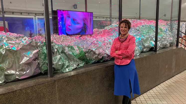 Konstnär Alexandra Larsson Jacobson framför konstmontern på Odenplans tunnelbanestation.
