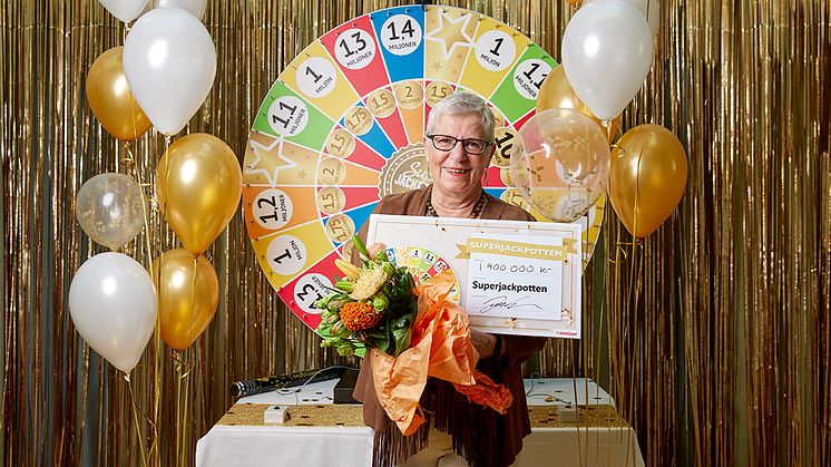 En omtumlad Kerstin poserar framför hjulet, nu är hon 1,4 miljoner kronor rikare.