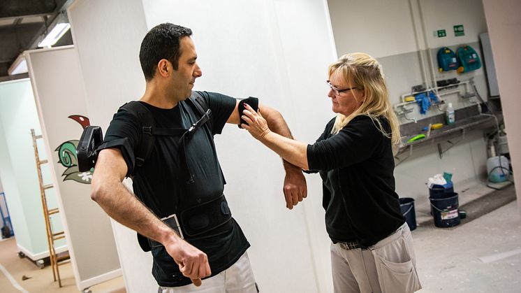 Anita Jensen hjælper Hamid med at få exoskelettet på.
