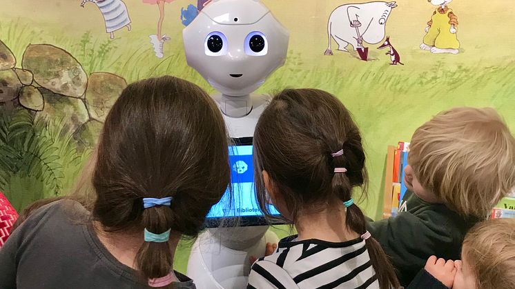 Barn bekantar sig med läsroboten Bibi på Skärholmens bibliotek